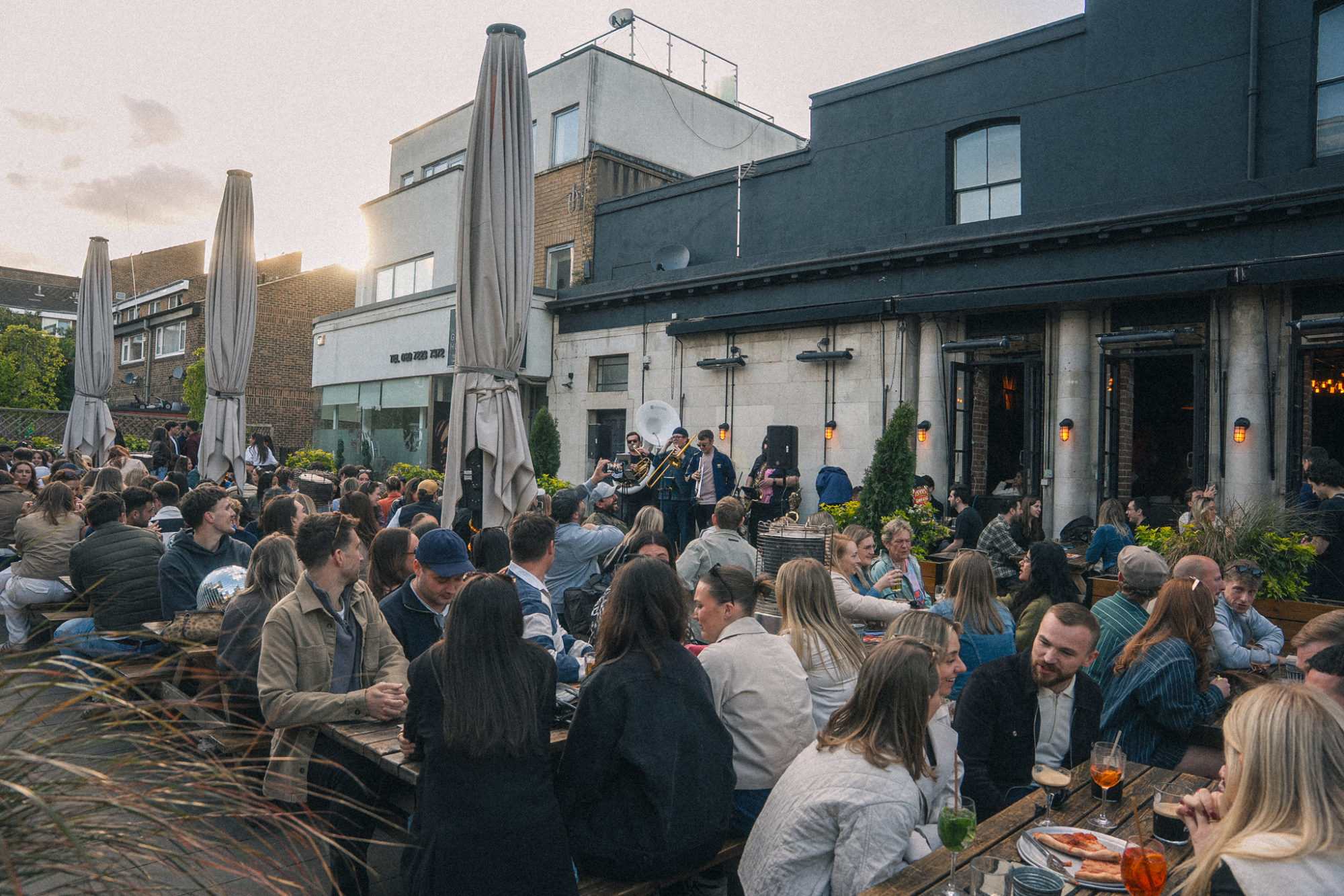 People sitting on tables in a beer garden.