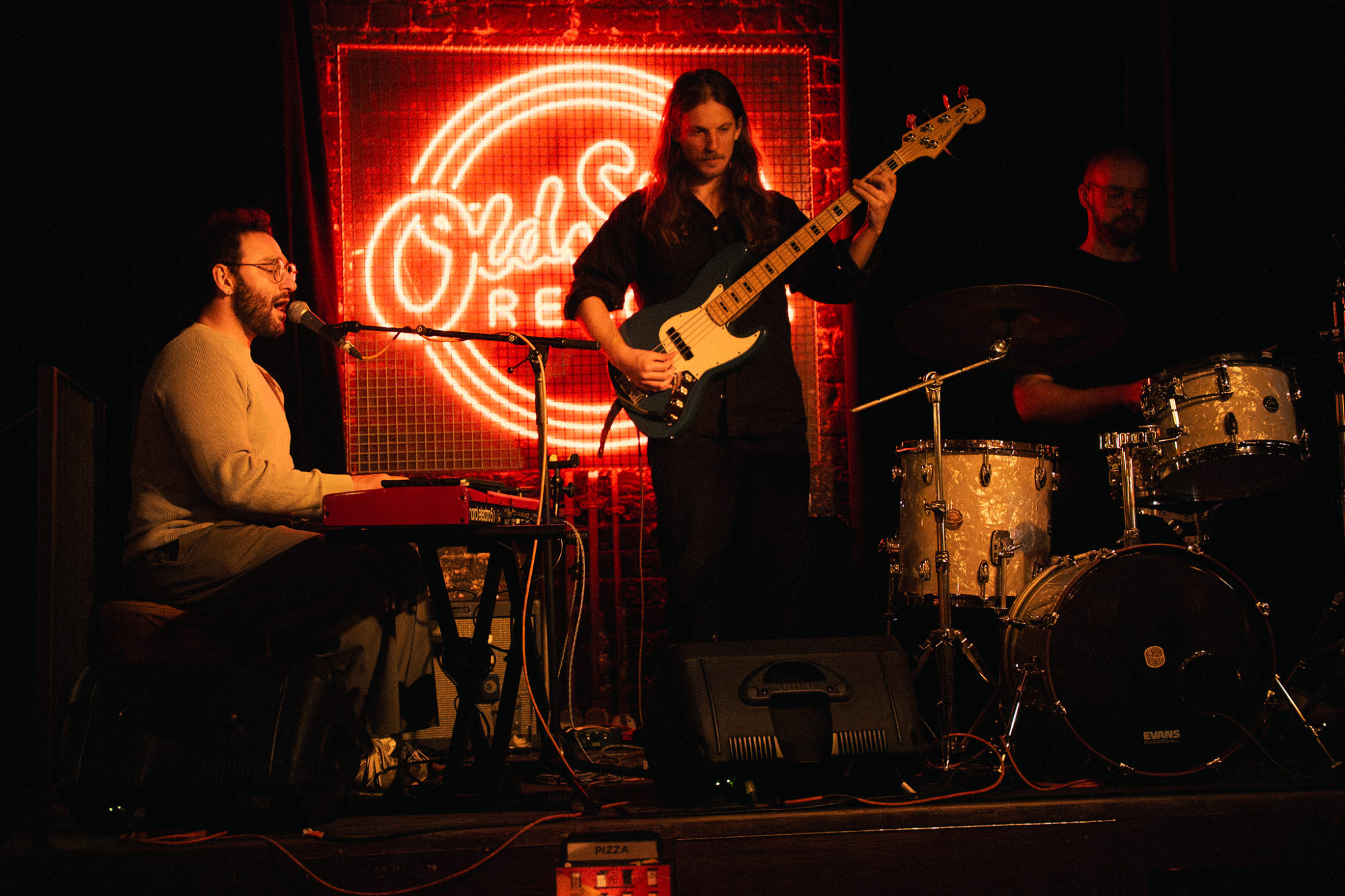 A group of musicians playing musical instruments such as a keyboard, electric guitar and drums.